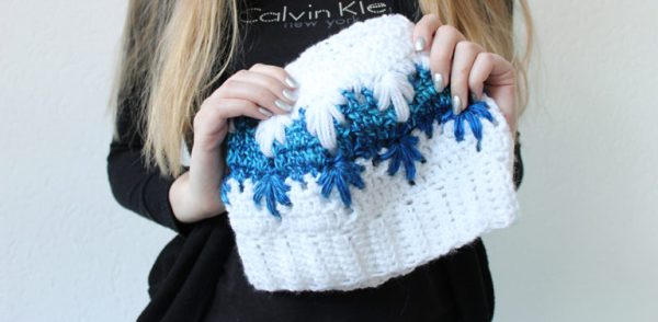 A woman holding the Frozen Winter Bun Crochet Hat 