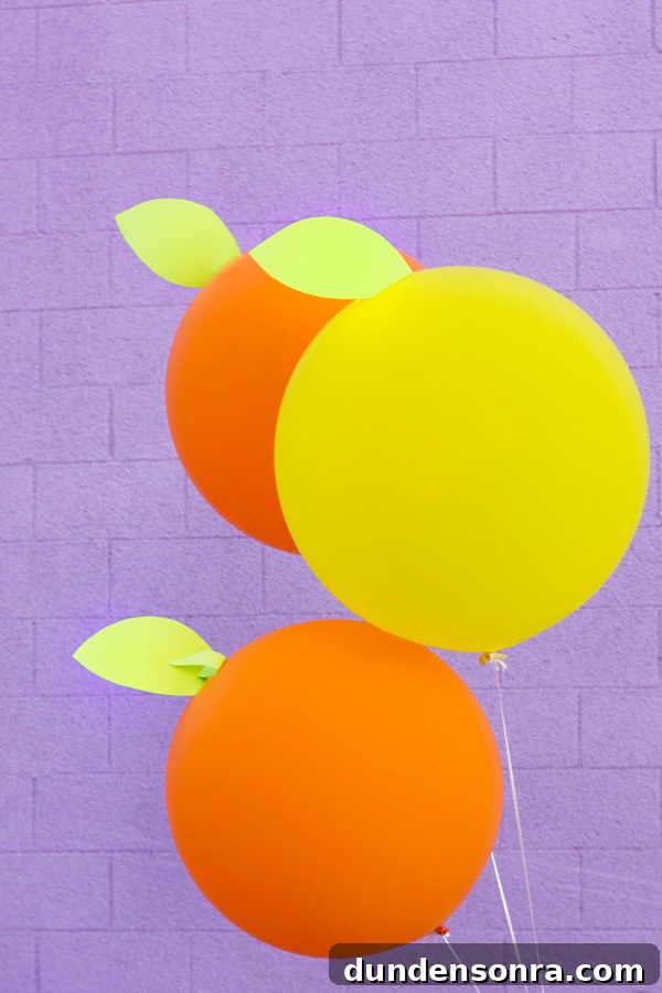 DIY Giant Citrus Balloons against a purple wall. 