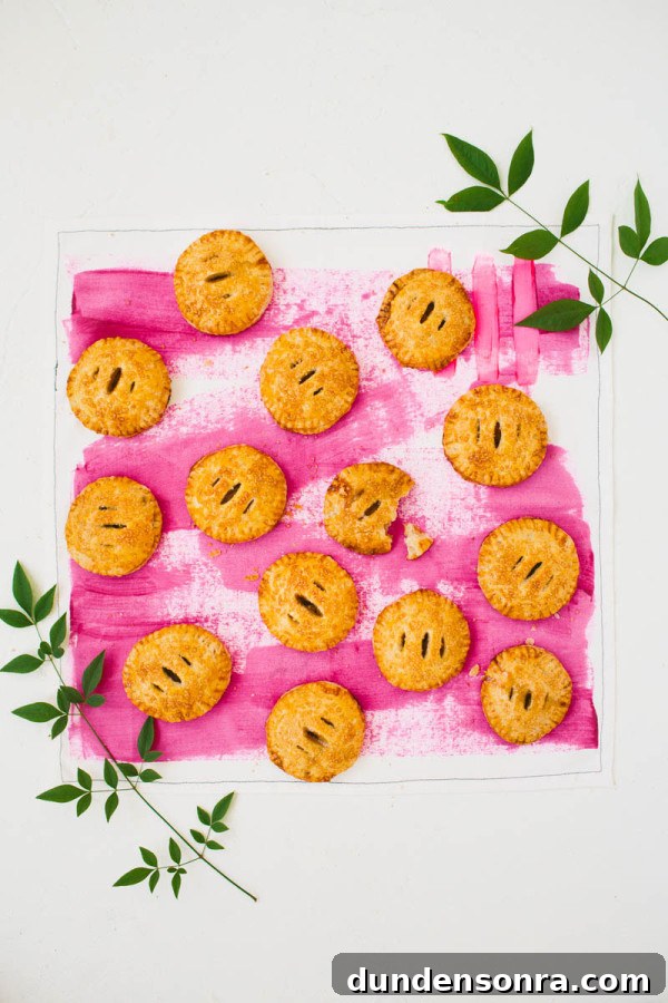Vanilla Cardamom Pear Hand Pies — Homemade Mini Dessert Pies 3 Mini pies on a pink surface