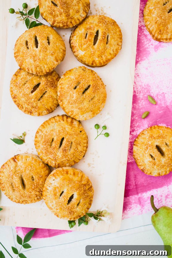 Vanilla Cardamom Pear Hand Pies — Homemade Mini Dessert Pies 4 Mini pies on a cutting board