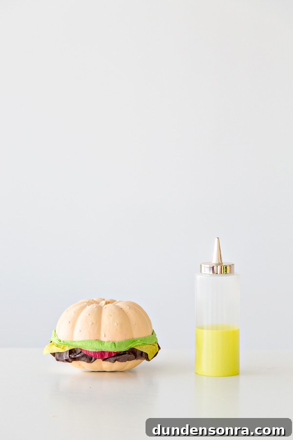 A fake burger and a bottle of yellow liquid 