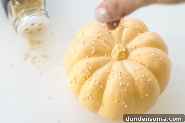 Someone putting seeds on a pumpkin 