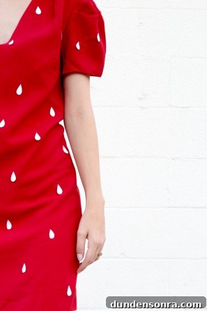 close up of red dress with white seeds on it