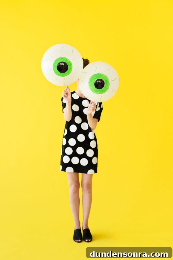 How to Make Spooky Eyeball Balloons for Halloween Decorations 2 Someone holding eyeball balloons