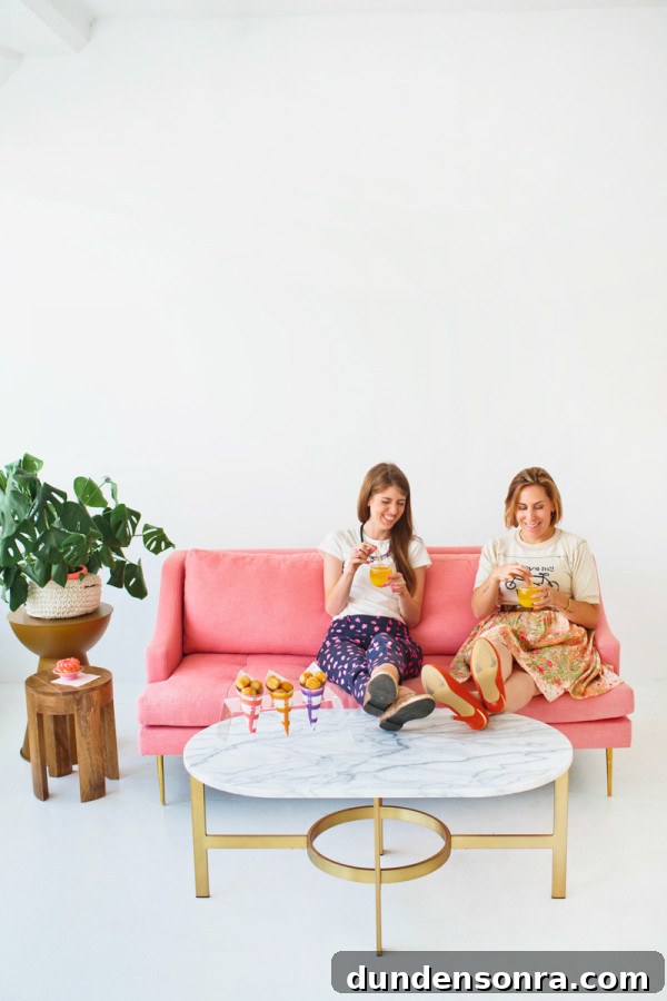 Two people sitting on a couch eating food