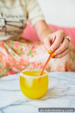 Someone putting a straw in an orange drink