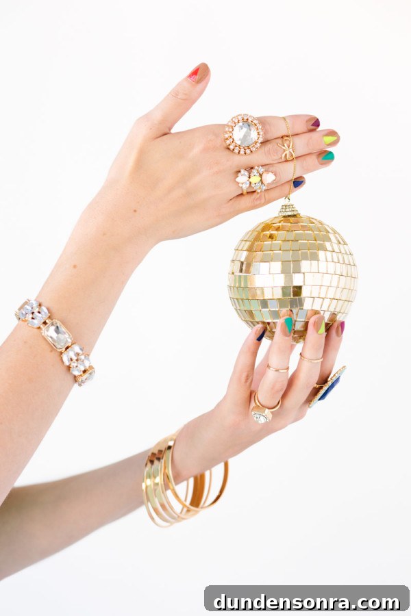 A woman holding a tiny gold disco ball