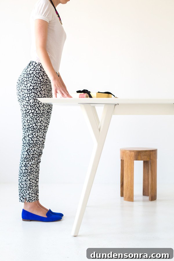 A woman standing next to a table making crafts