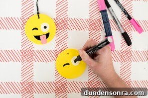 Someone drawing an emoji face on a ornament 