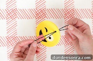 Someone making an emoji ornament 