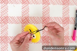 Someone making an emoji ornament 