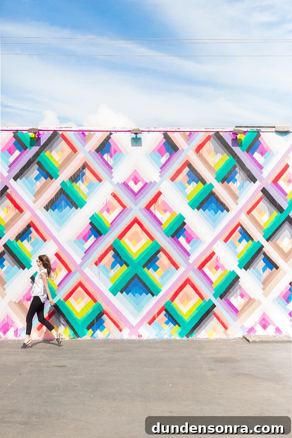 A woman in front of a colorful mural 