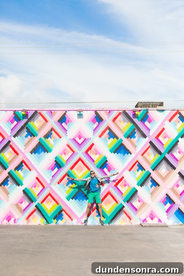 A man in front of a colorful mural 