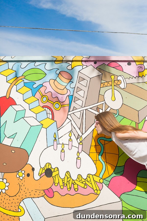 A woman in front of a colorful mural 