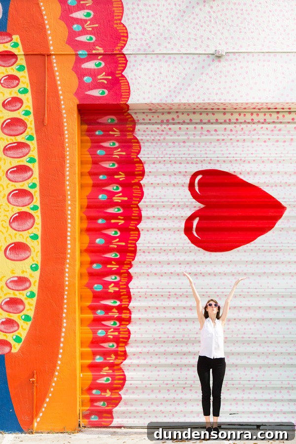 A woman in front of a red and yellow mural 