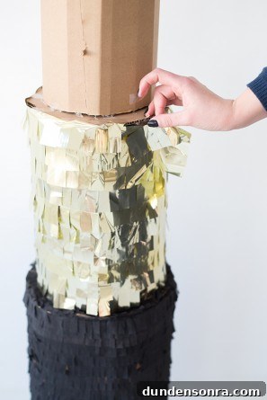 Someone putting gold decor on cardboard 