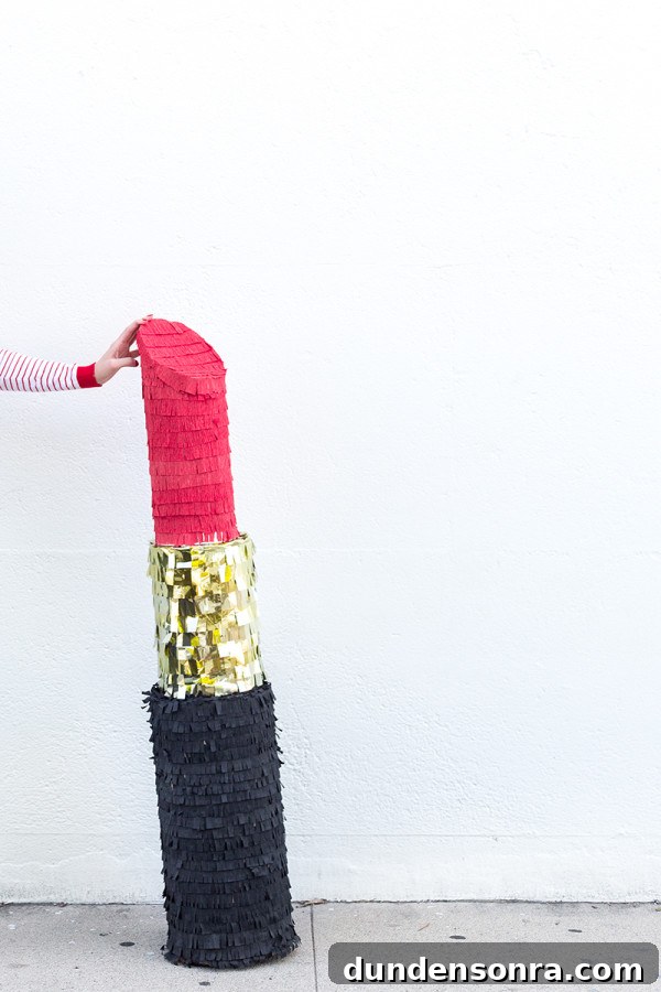 Someone holding a lipstick piñata 