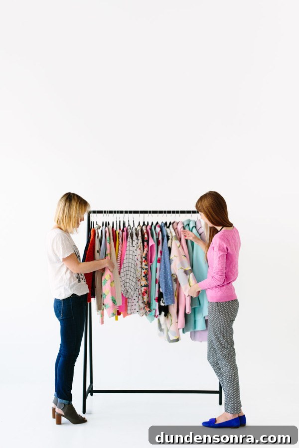 Two women looking at a colorful clothing rack