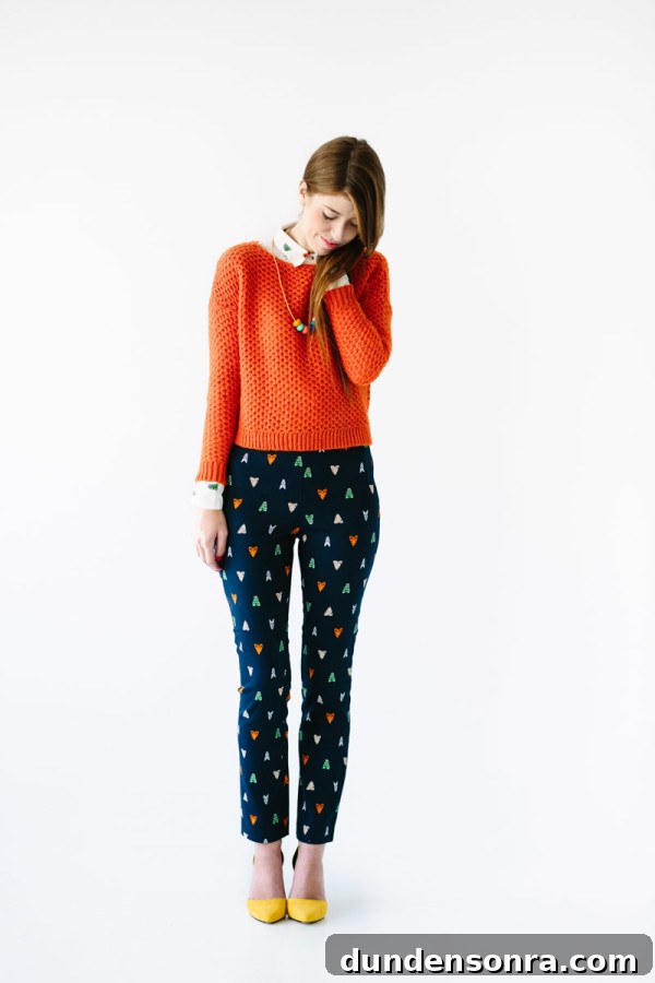 A woman wearing an orange sweater with blue pants
