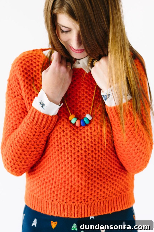 A woman wearing an orange sweater