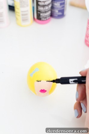 Someone drawing a face on an egg