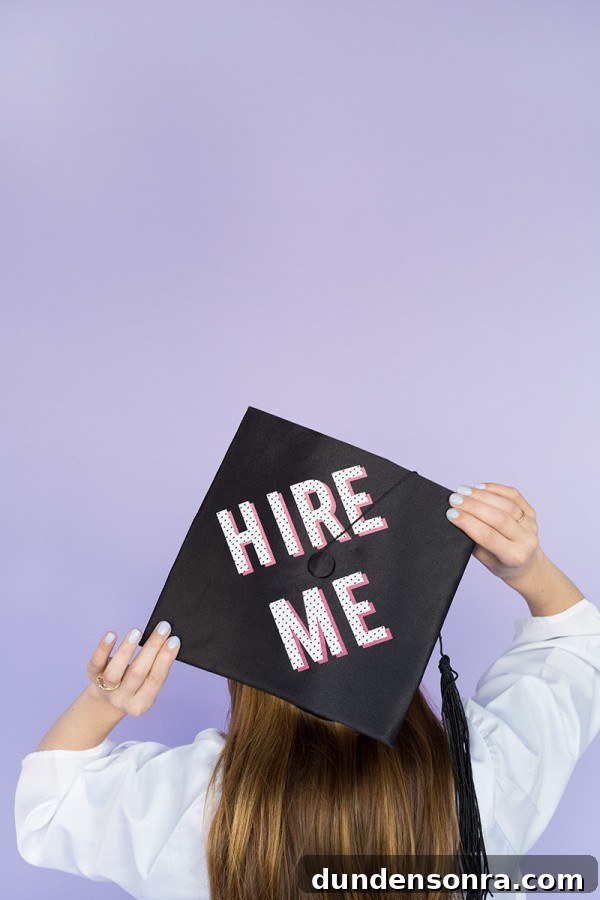 The back of a graduation cap that says "hire me"