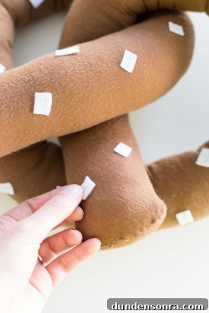 Someone putting white fabric on brown fabric