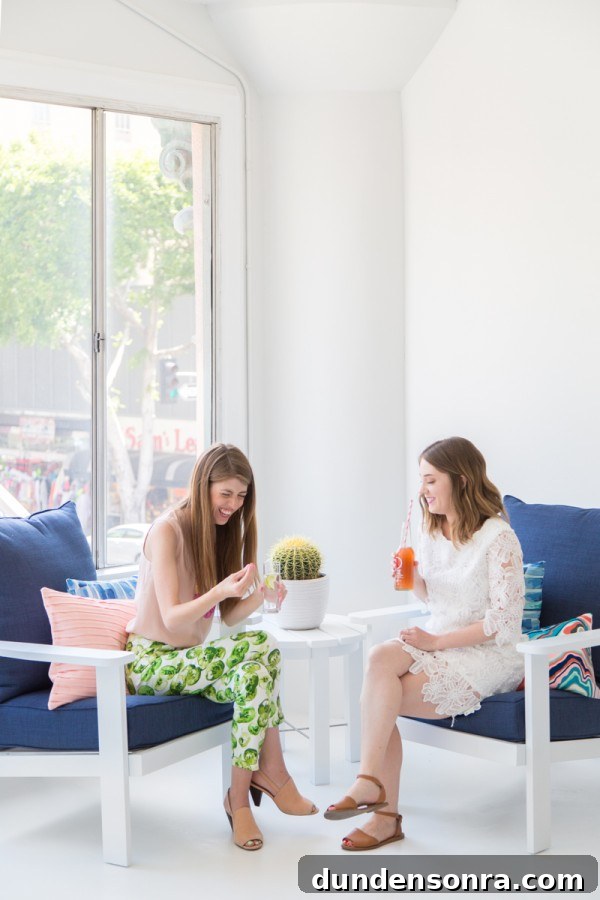 Two girls sitting on blue chairs talking