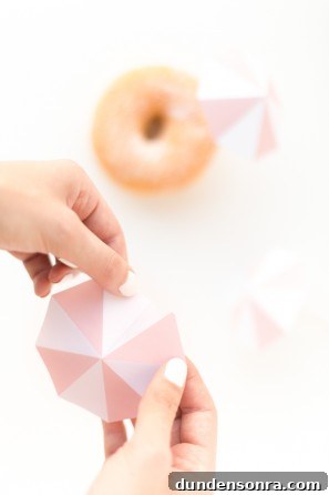 Someone putting a little umbrella on a donut