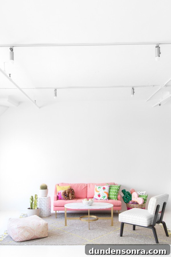 A room with a pink couch and cactus decor