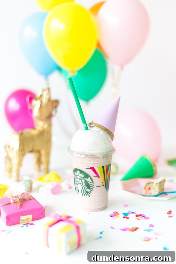 A close up of a starbucks drink with party decor in the background