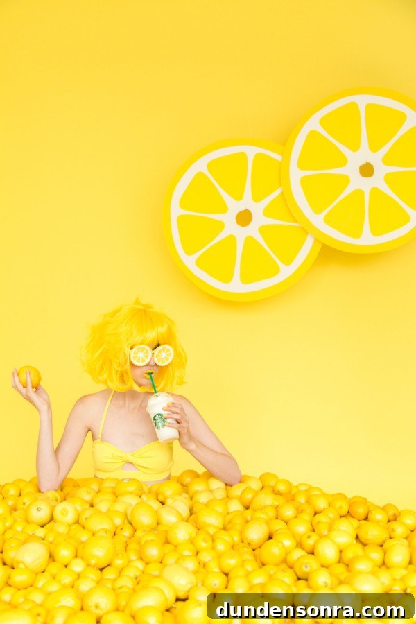 A woman sitting in lemons and drinking a drink