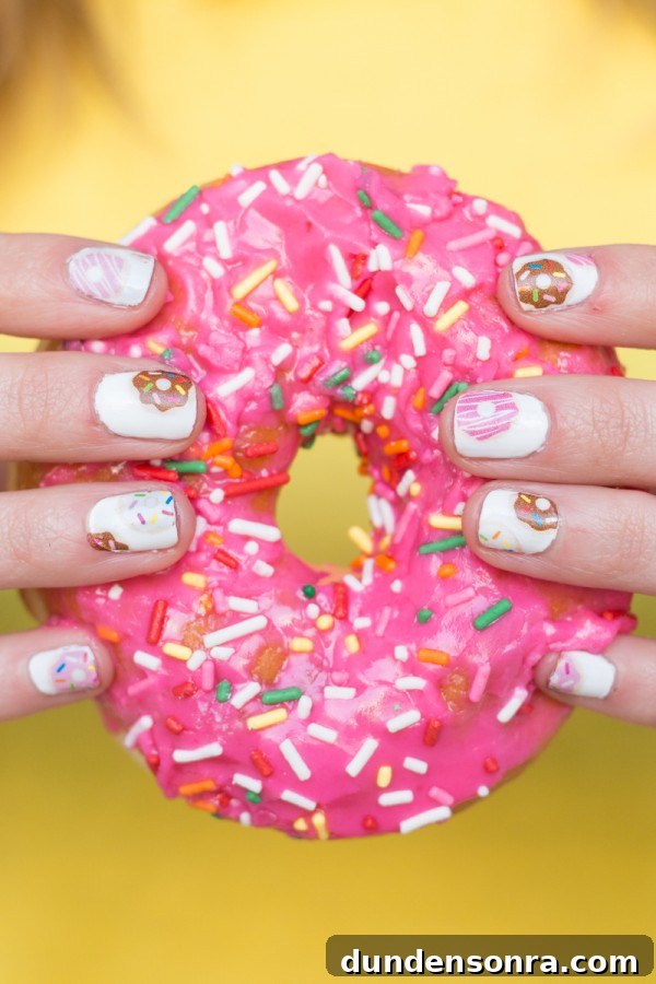 DIY Donut Nail Decals: Fun Printable Nail Art Designs 14 Someone holding a pink donut