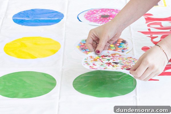 Someone putting donut stickers on a twister game