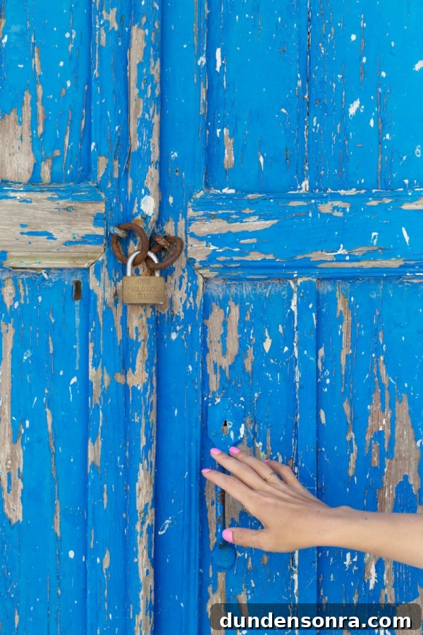 Honeymoon in Santorini: Meet the Mindells' Romantic Getaway 11 Someone touching a blue door