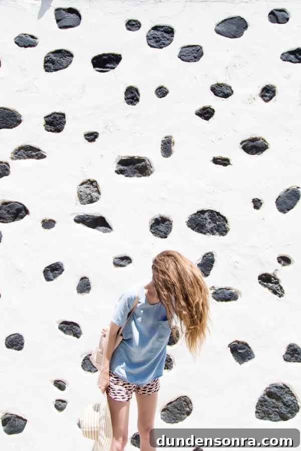 Honeymoon in Santorini: Meet the Mindells' Romantic Getaway 14 A woman whipping her hair around in front of a black and white wall