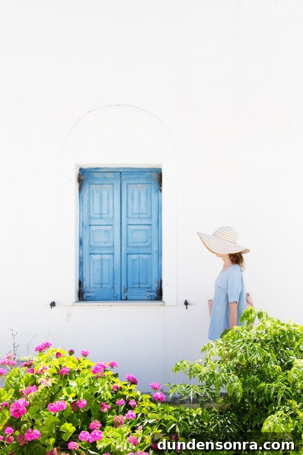 Honeymoon in Santorini: Meet the Mindells' Romantic Getaway 22 A woman walking past a blue window