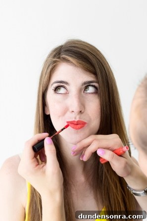 A woman putting lip product on