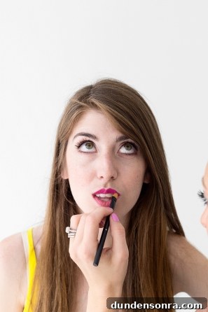 Someone putting lip product on