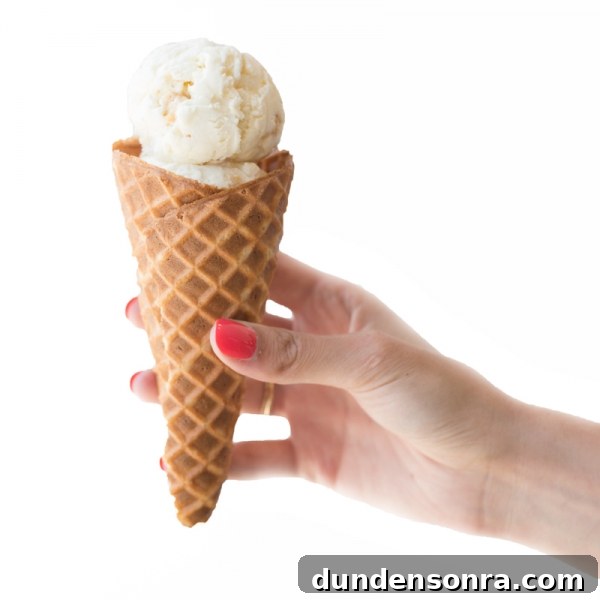 Someone holding a cone with ice cream