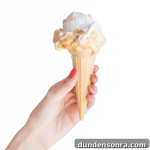 Someone holding a cone with ice cream