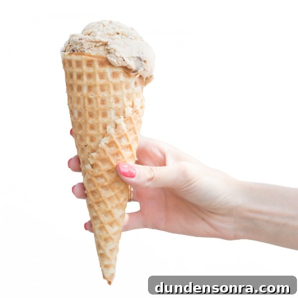Someone holding a cone with ice cream