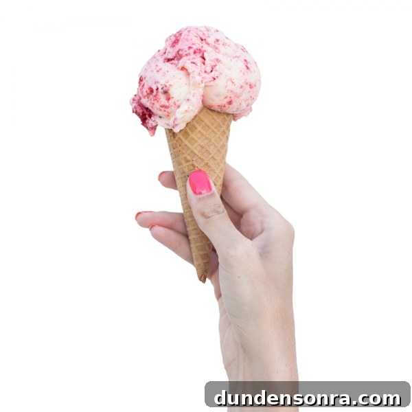 Someone holding a cone with ice cream
