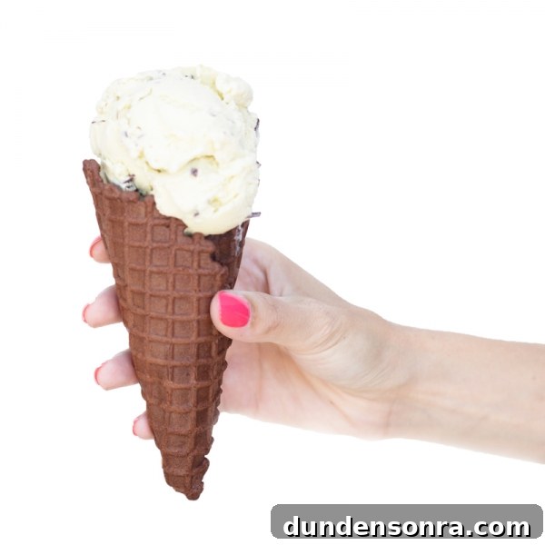 Someone holding a cone with ice cream