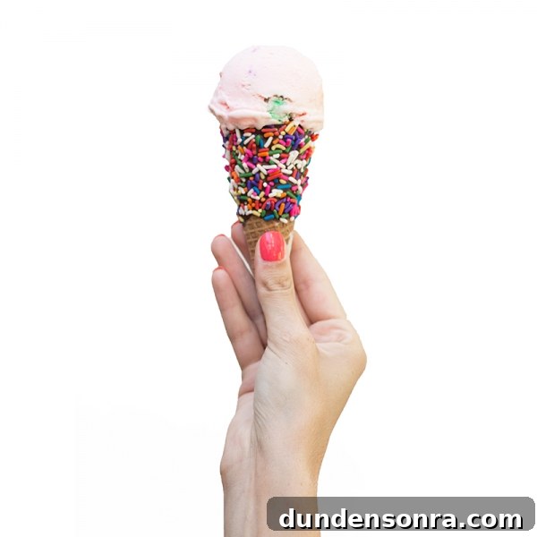 Someone holding a cone with ice cream