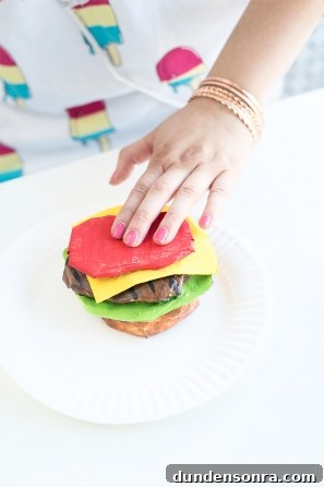 Someone holding a paper mache burger