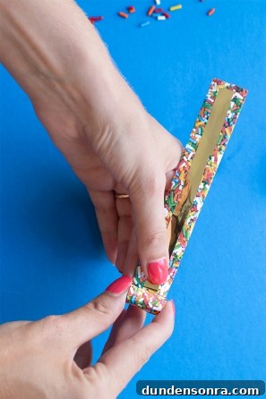 Someone holding a paper with sprinkles and gold paper