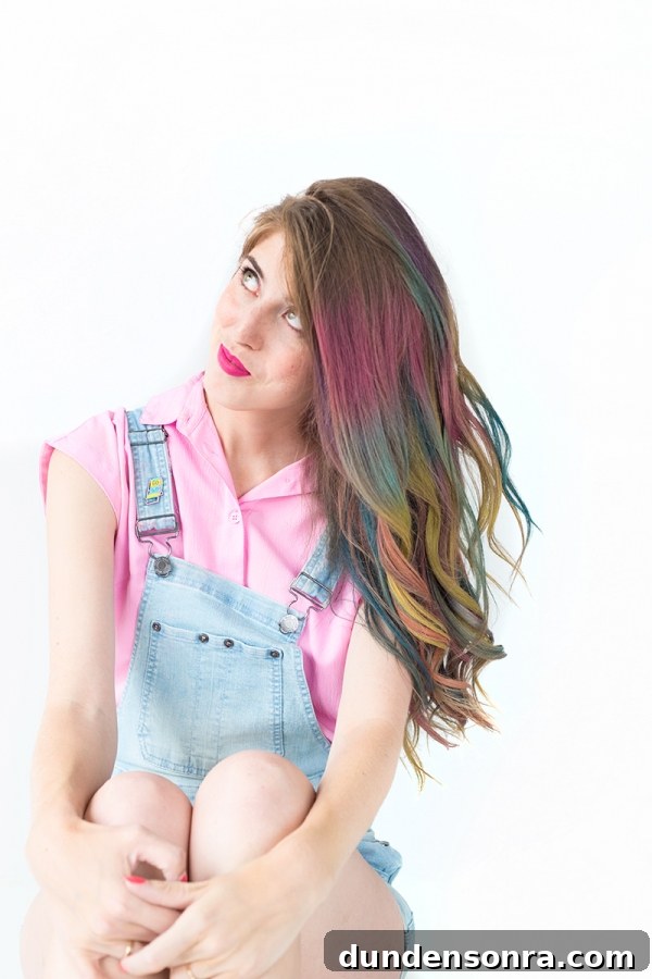 A woman with rainbow hair wearing overalls