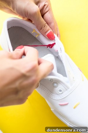 DIY Ice Cream Sneakers: How to Paint and Customize Your Shoes 9 Someone sewing strings on a white sneaker