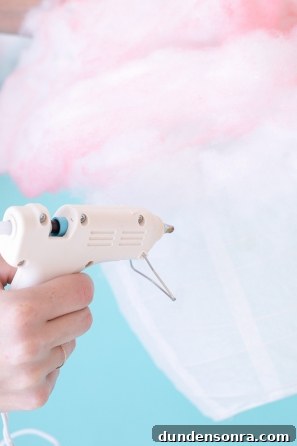 How to Make a Cotton Candy Piñata for Parties and Birthdays 6 Someone gluing pink cotton